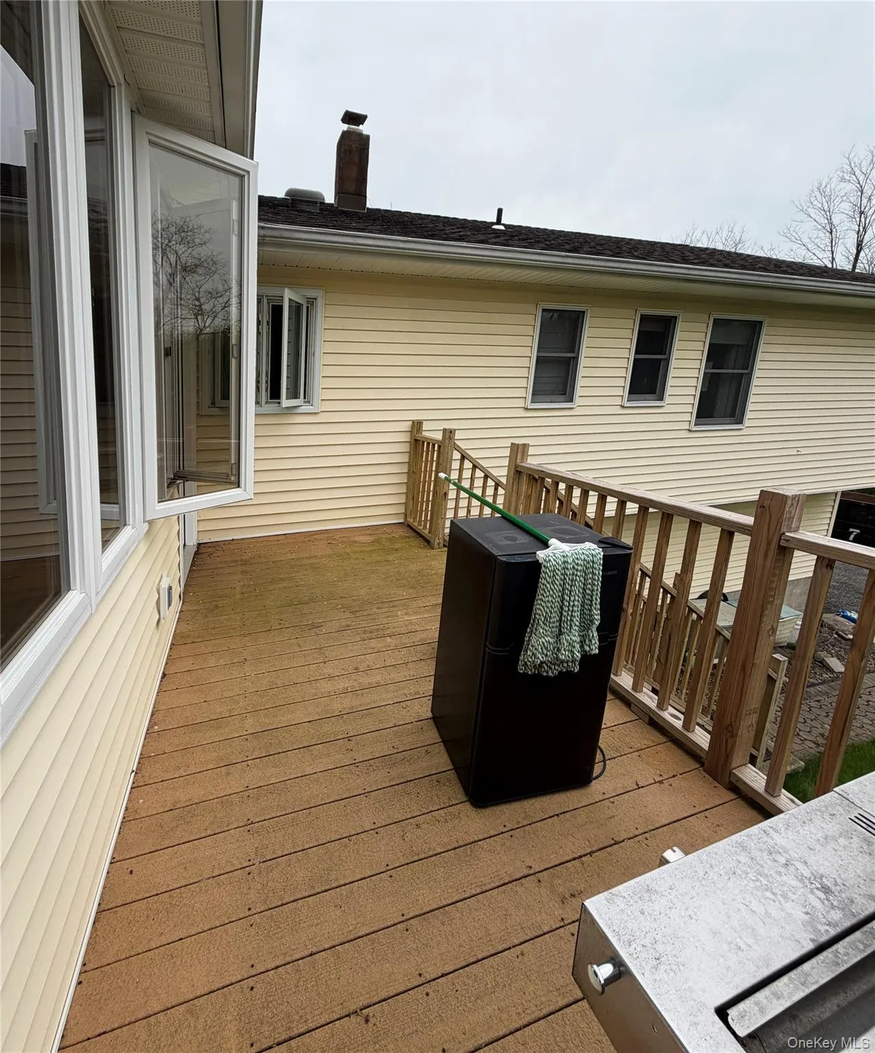 Expansive exterior deck featuring wood-finish decking, wood railings, and a bay window Expansive exterior deck featuring wood-finish decking, wood railings, and a bay window