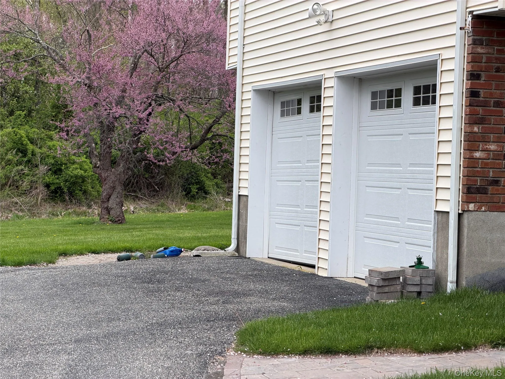 Two garage bays with panel doors and upper window inserts Two garage bays with panel doors and upper window inserts