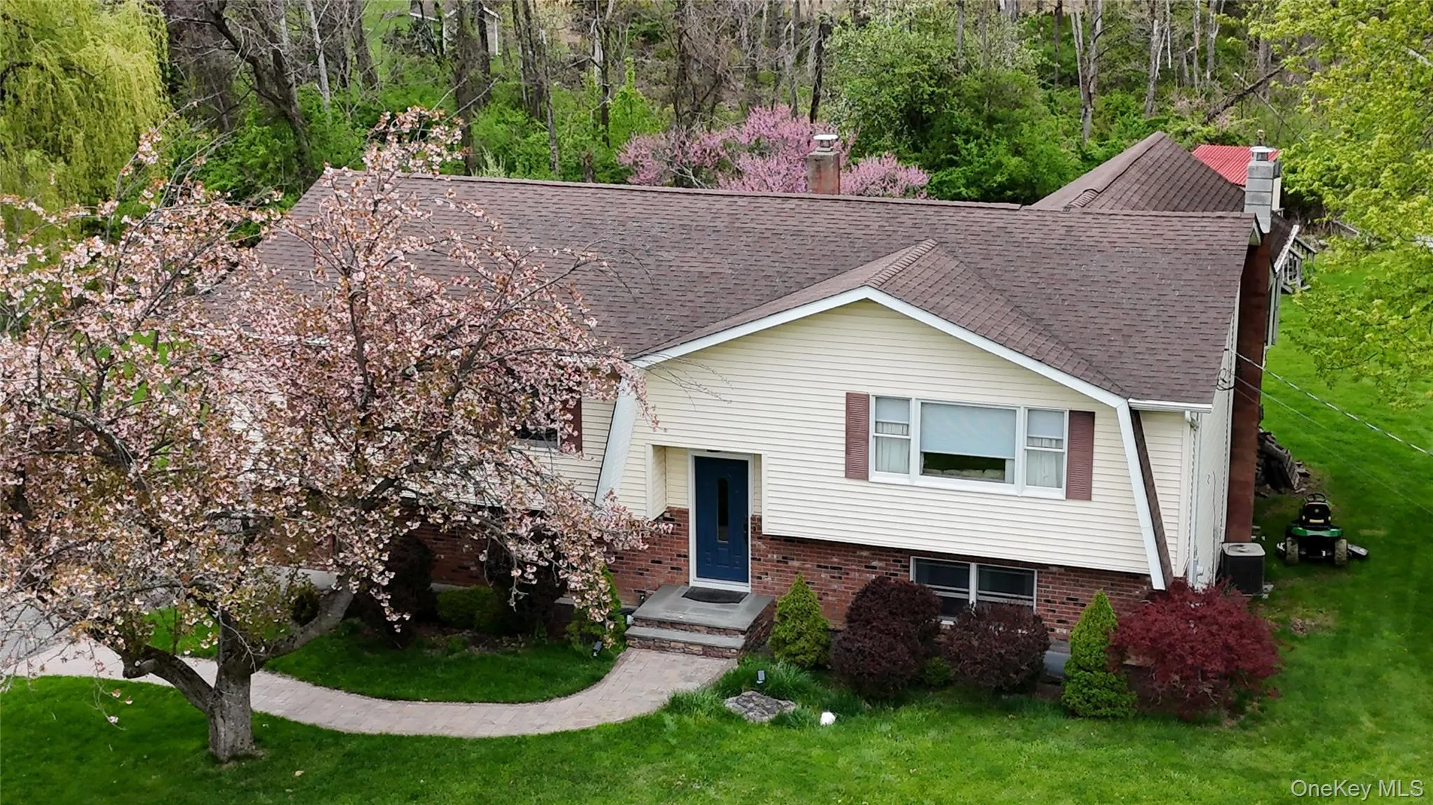Ariel view of front and side of structure from 50' above ground level featuring well manicured lawn with flowing trees, and evergreen and deciduous shrubs Ariel view of front and side of structure from 50' above ground level featuring well manicured lawn with flowing trees, and evergreen and deciduous shrubs