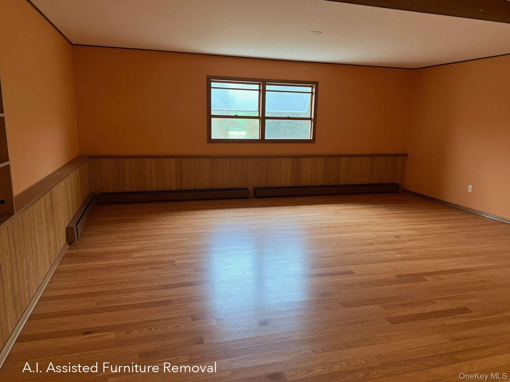 Spacious first floor room featuring hard wood flooring, wood paneling, and a large window Spacious first floor room featuring hard wood flooring, wood paneling, and a large window