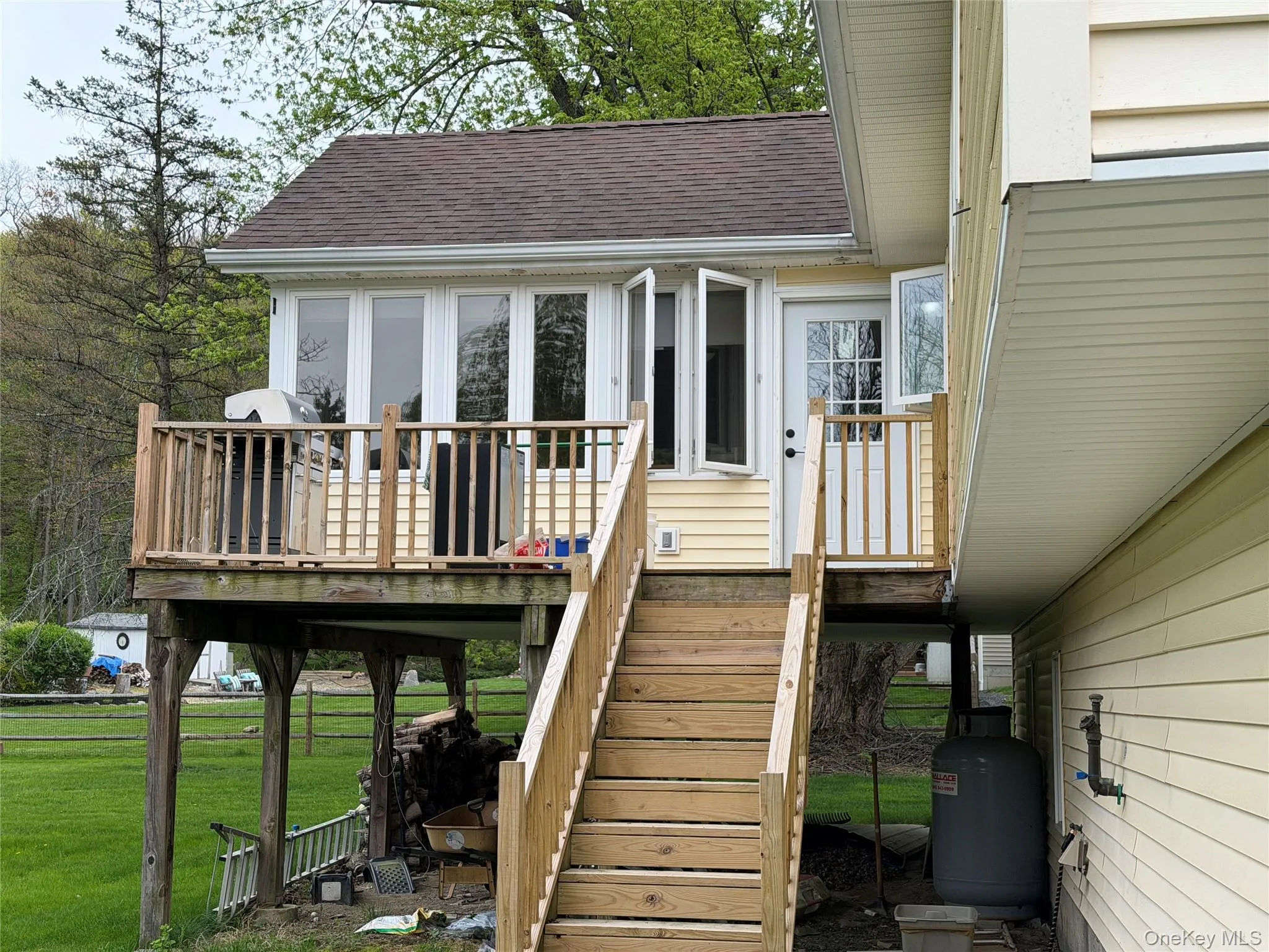 Elevated wood deck with natural wood railings, stairs to yard Elevated wood deck with natural wood railings, stairs to yard
