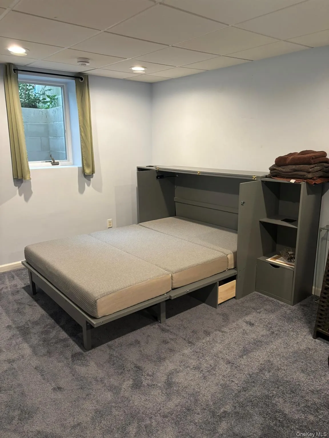 Bedroom with a paneled ceiling and carpet floors Bedroom with a paneled ceiling and carpet floors