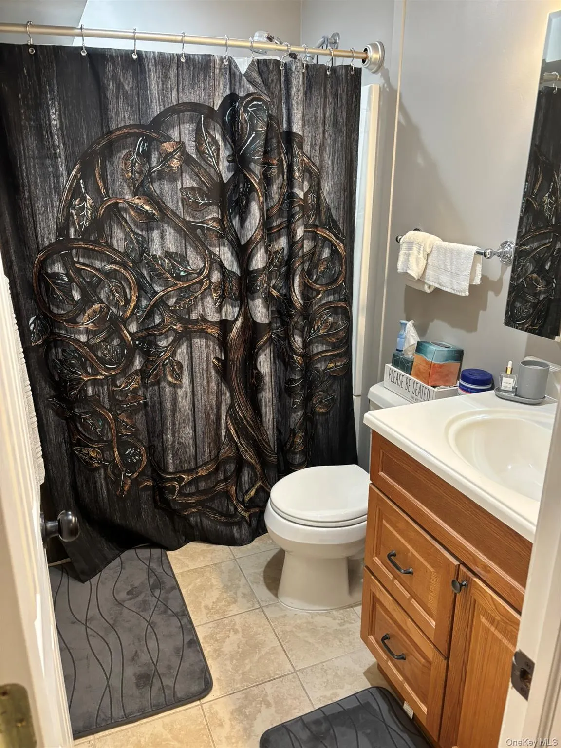 Full bathroom with tile patterned floors, vanity, and curtained shower Full bathroom with tile patterned floors, vanity, and curtained shower