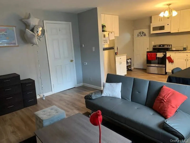 Living area with light wood-type flooring and a chandelier Living area with light wood-type flooring and a chandelier