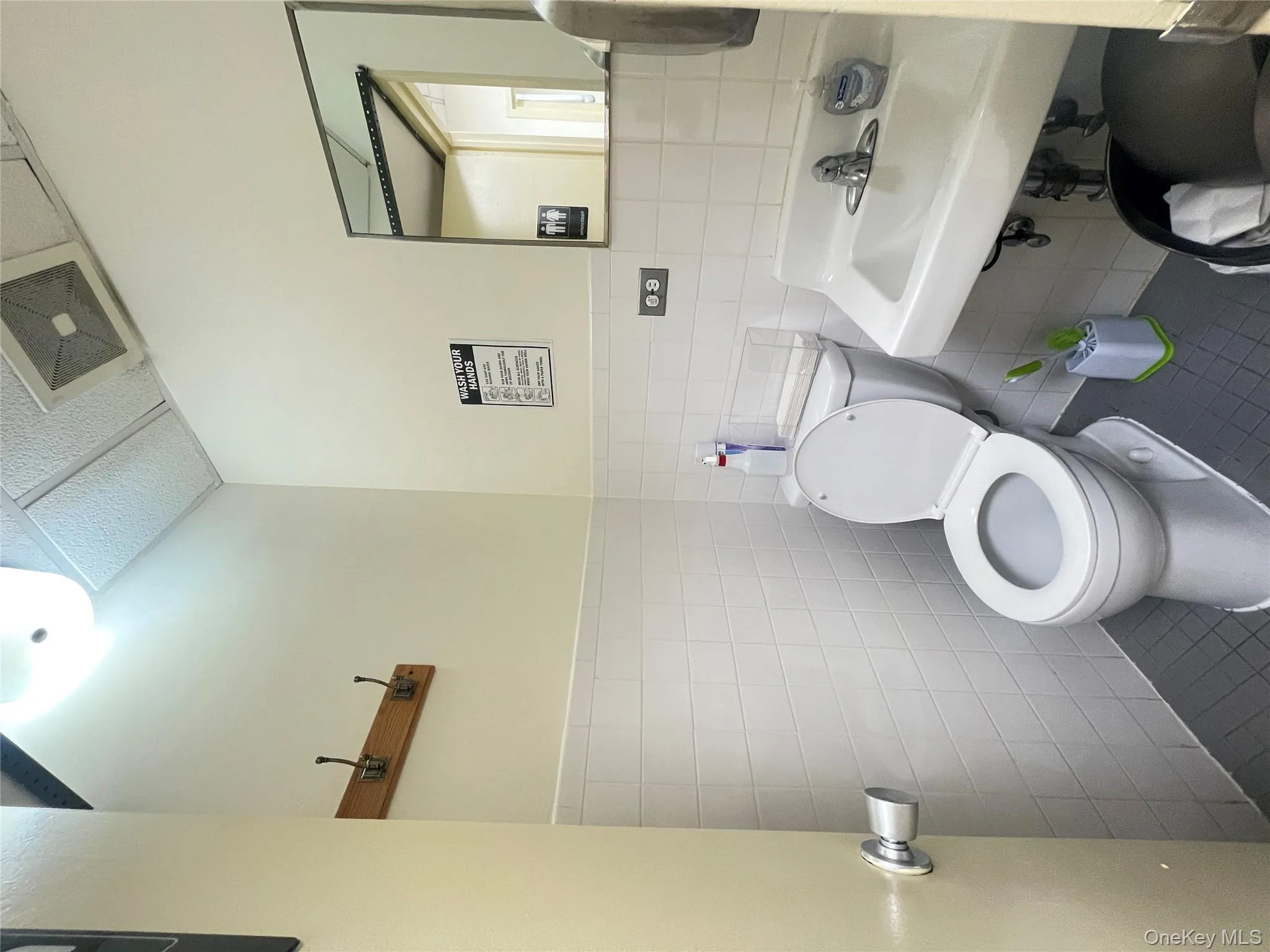Bathroom with tile patterned flooring, tile walls, and a wainscoted wall Bathroom with tile patterned flooring, tile walls, and a wainscoted wall