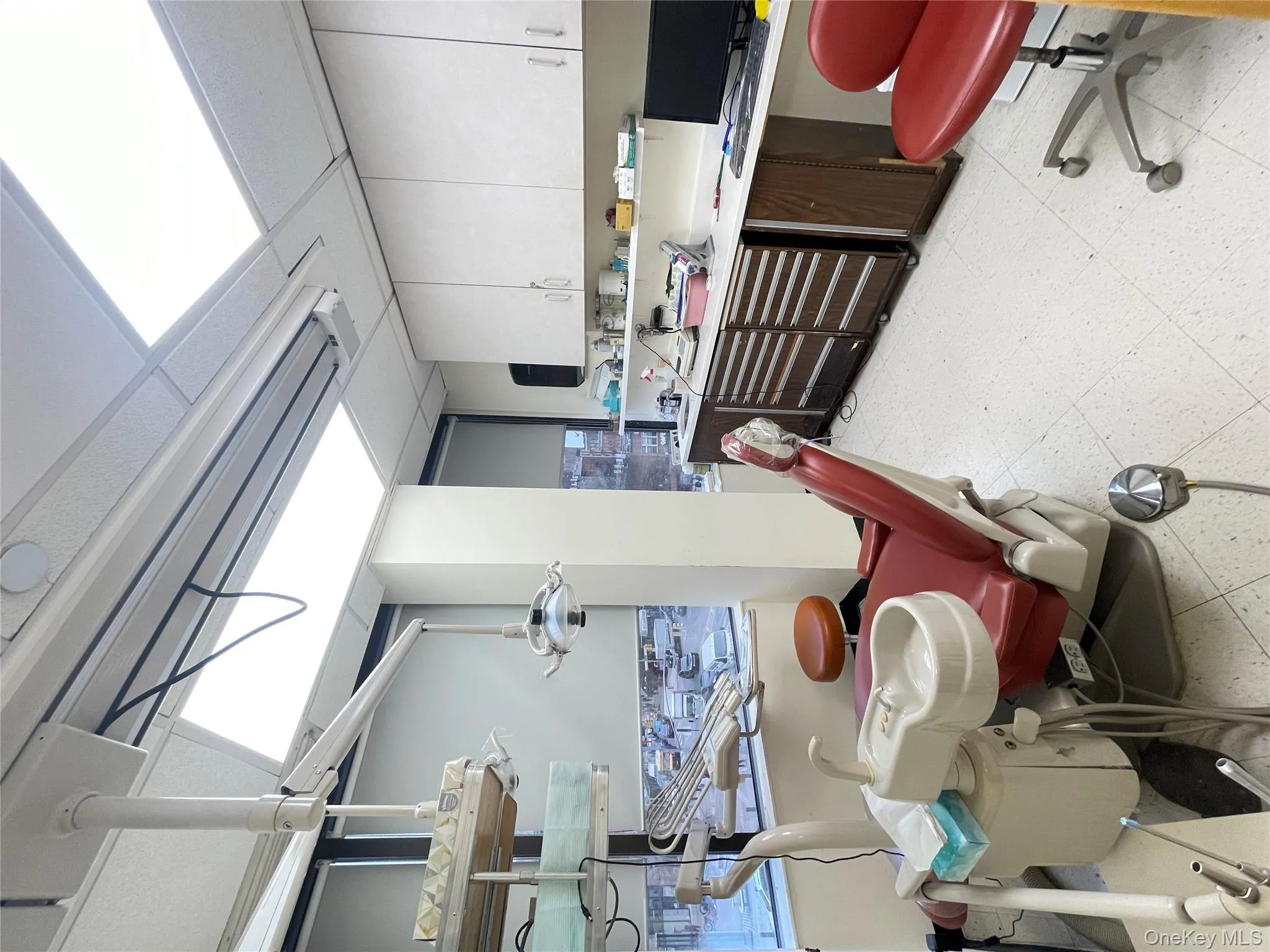 Kitchen featuring light flooring, a drop ceiling, light countertops, and white cabinets Kitchen featuring light flooring, a drop ceiling, light countertops, and white cabinets