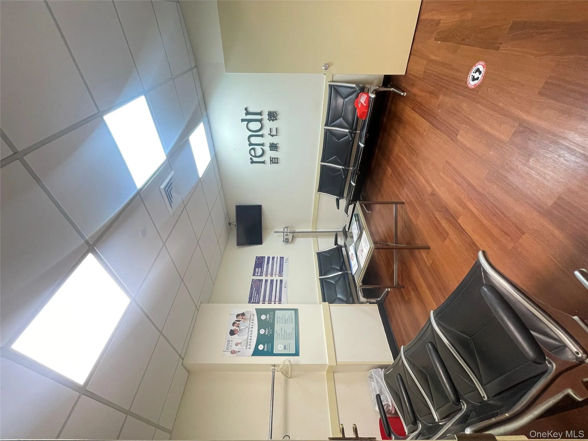 Living room featuring wood finished floors and a paneled ceiling Living room featuring wood finished floors and a paneled ceiling