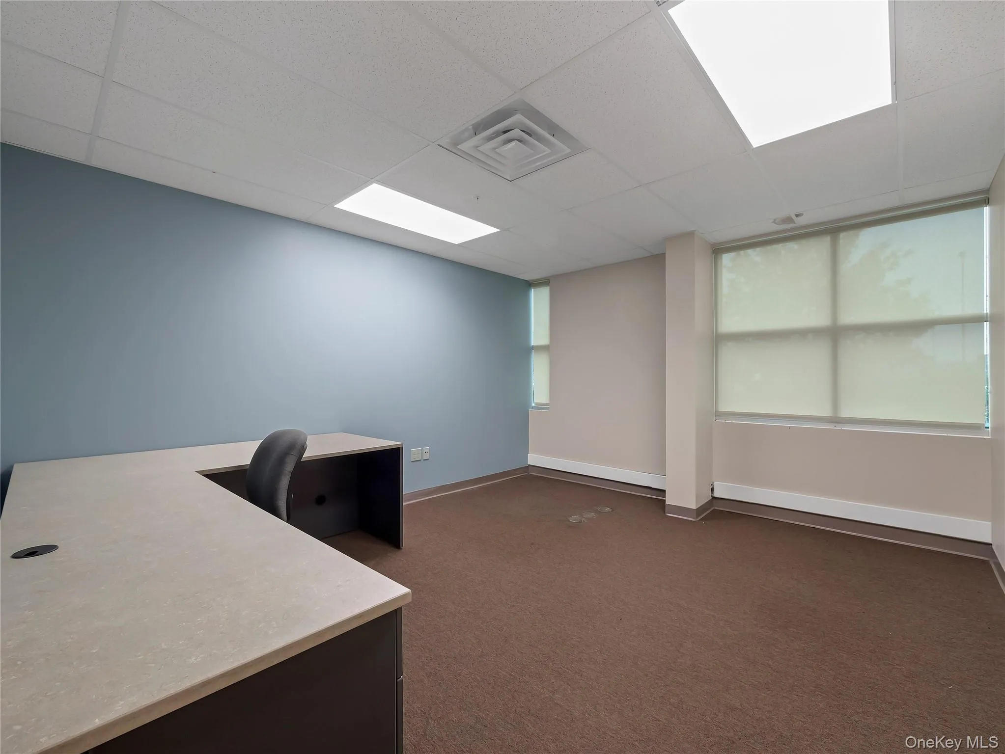Unfurnished office with dark carpet and a paneled ceiling Unfurnished office with dark carpet and a paneled ceiling