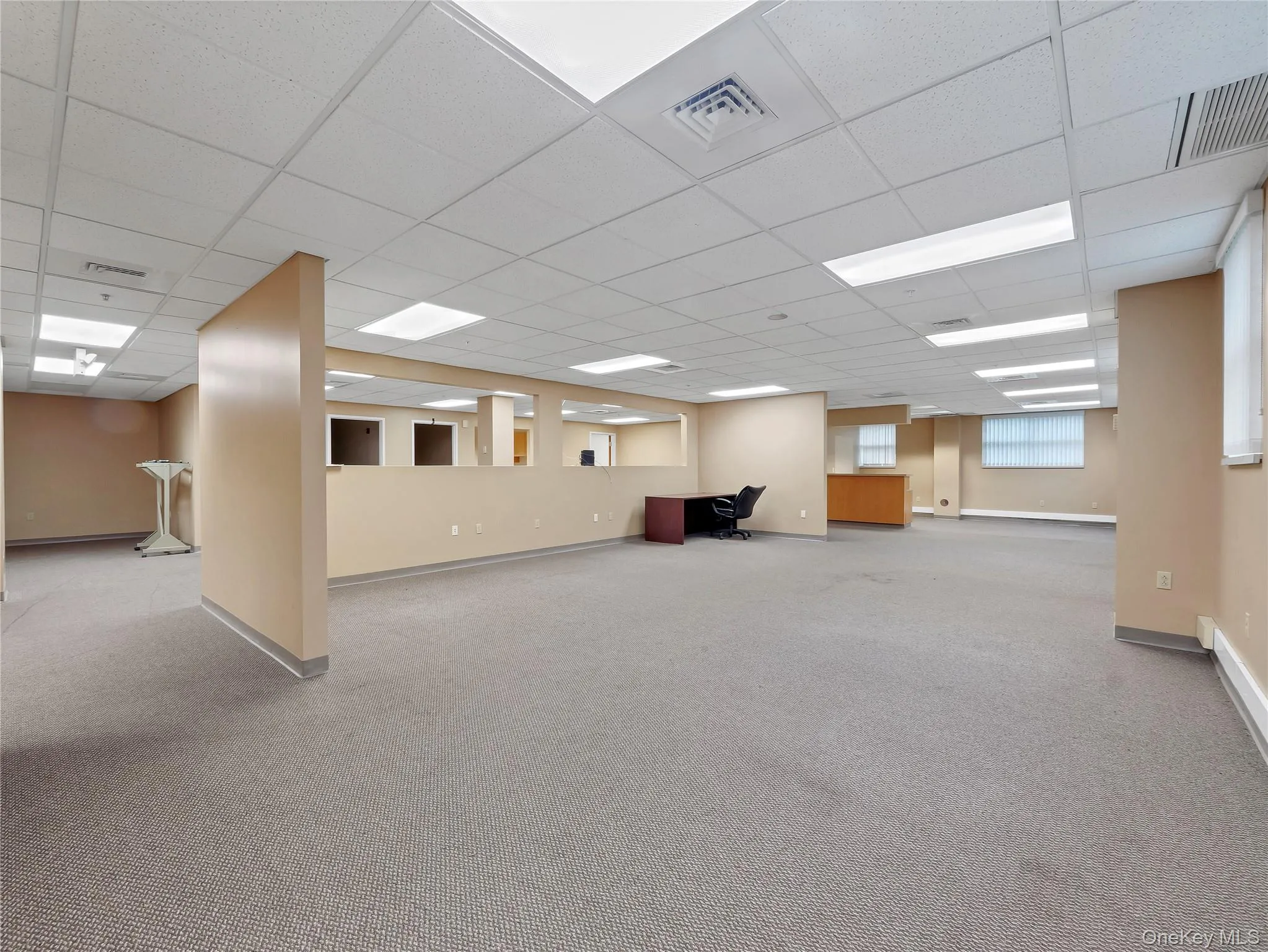 Basement featuring carpet flooring, a drop ceiling, and an office area Basement featuring carpet flooring, a drop ceiling, and an office area