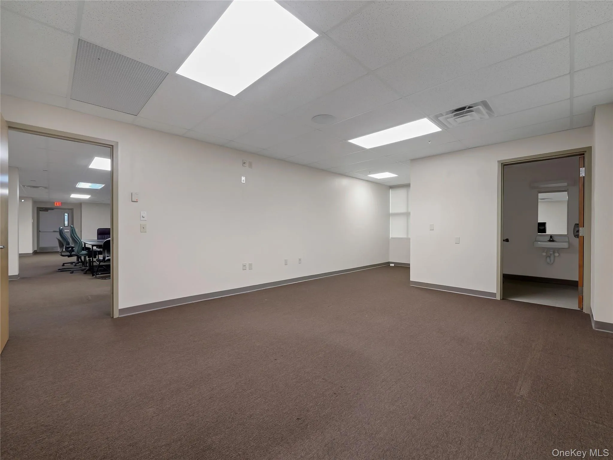 Spare room with a paneled ceiling and dark colored carpet Spare room with a paneled ceiling and dark colored carpet