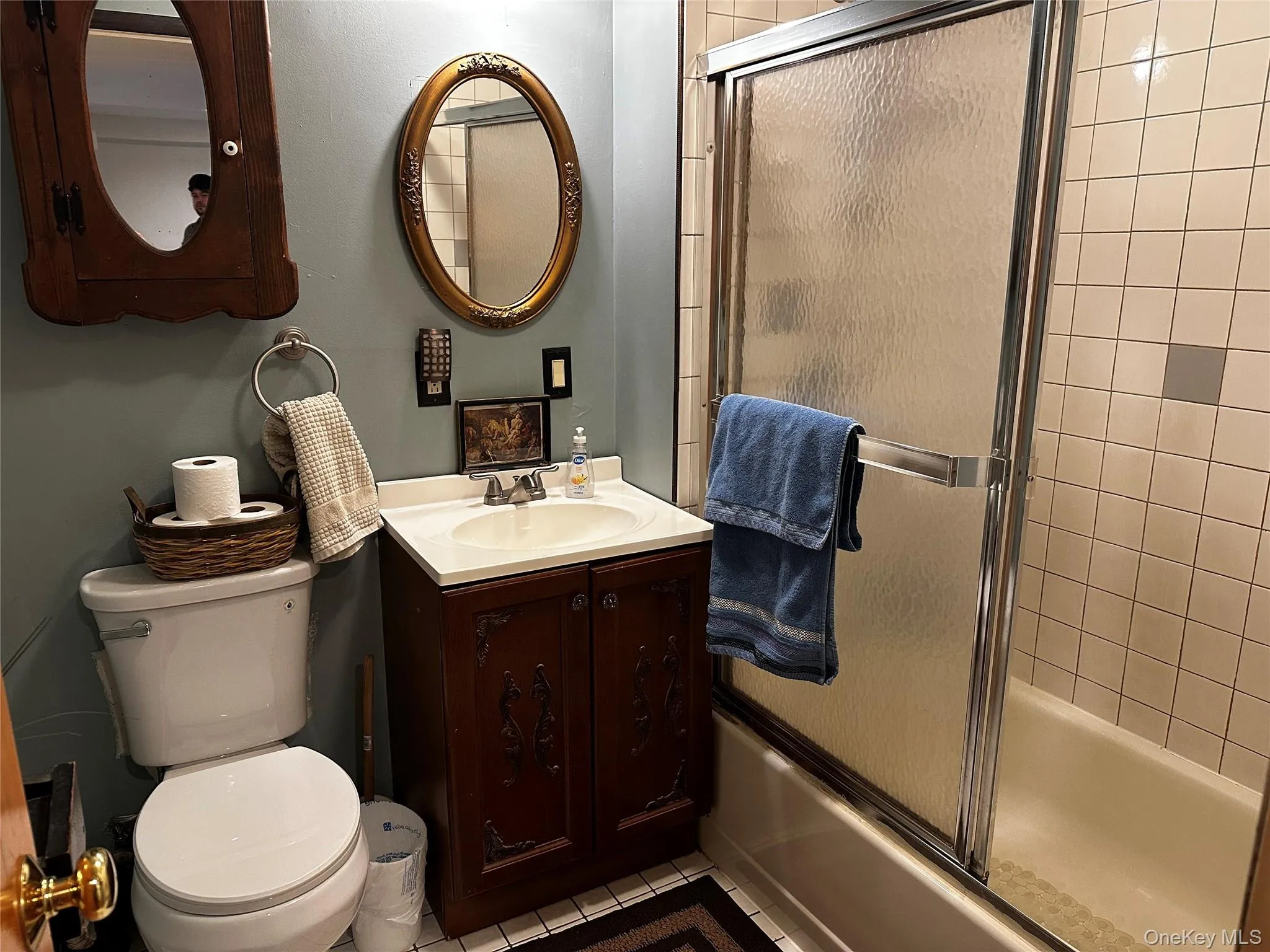 Full bath with tile patterned flooring, bath / shower combo with glass door, and vanity Full bath with tile patterned flooring, bath / shower combo with glass door, and vanity