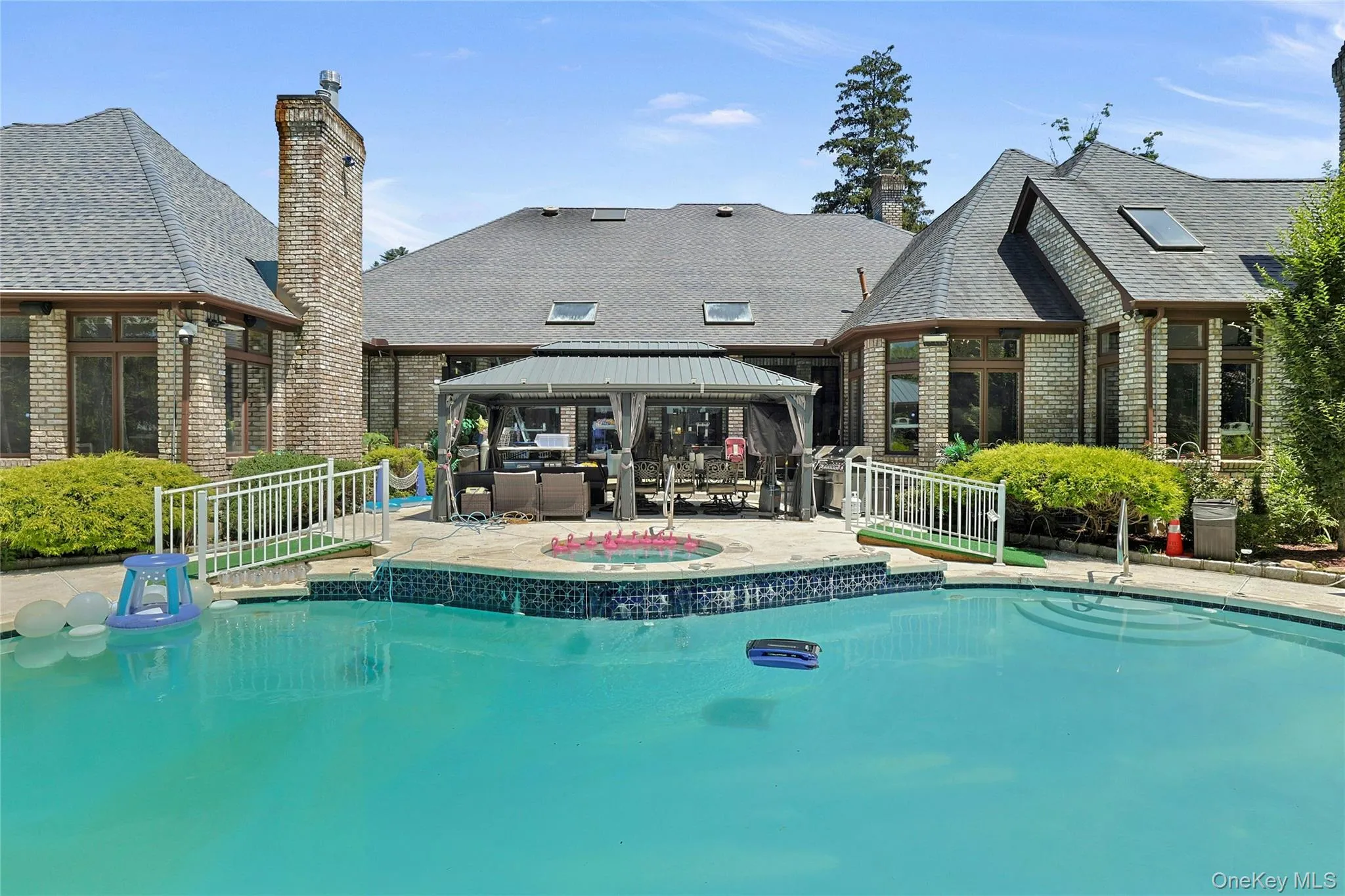 Outdoor pool with a gazebo, a patio area, and an in-ground hot tub Outdoor pool with a gazebo, a patio area, and an in-ground hot tub