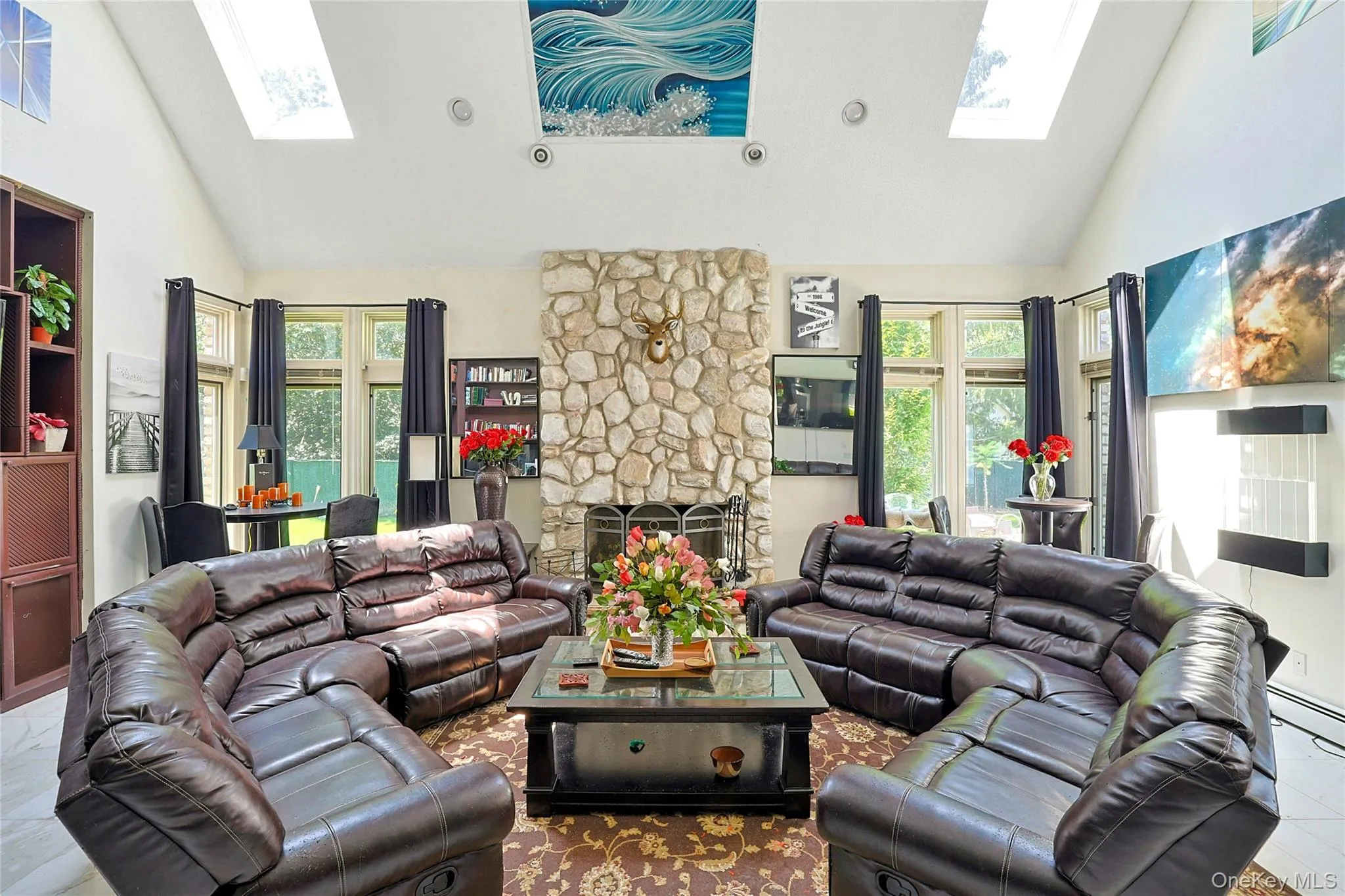 Family room with a skylight, high vaulted ceiling, and a fireplace Family room with a skylight, high vaulted ceiling, and a fireplace