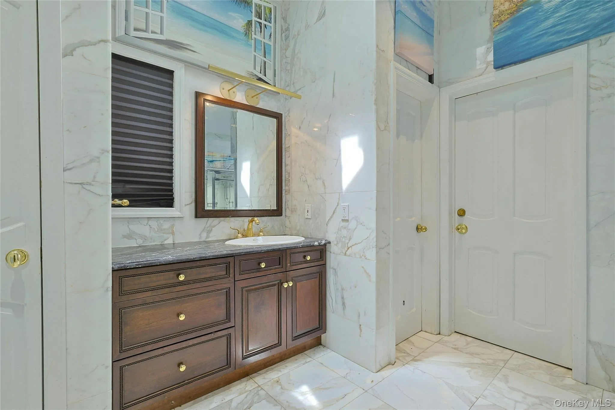 Bathroom featuring light marble finish flooring, stone wall, vanity, and tile walls Bathroom featuring light marble finish flooring, stone wall, vanity, and tile walls