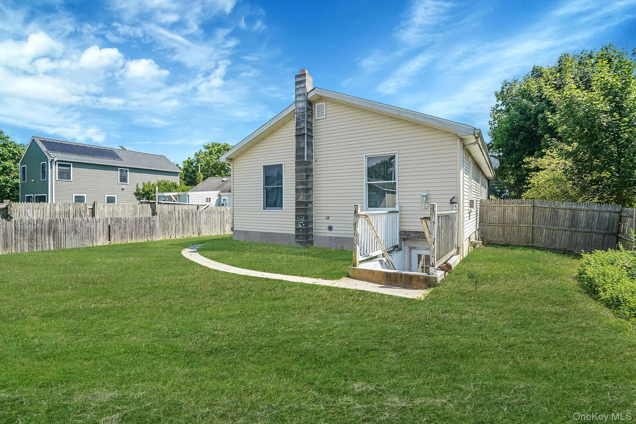 Rear view of house with a fenced backyard and a chimney Rear view of house with a fenced backyard and a chimney