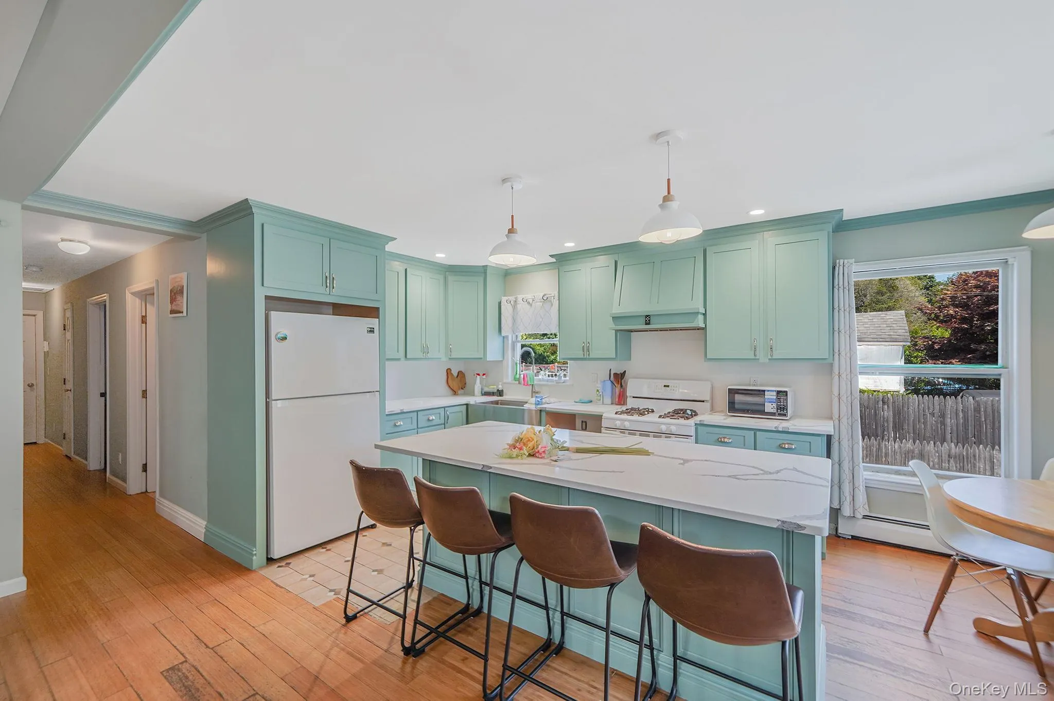 UPDATED Kitchen with center island, Quartz countertops, white appliances, light wood-type flooring, pendant lighting UPDATED Kitchen with center island, Quartz countertops, white appliances, light wood-type flooring, pendant lighting