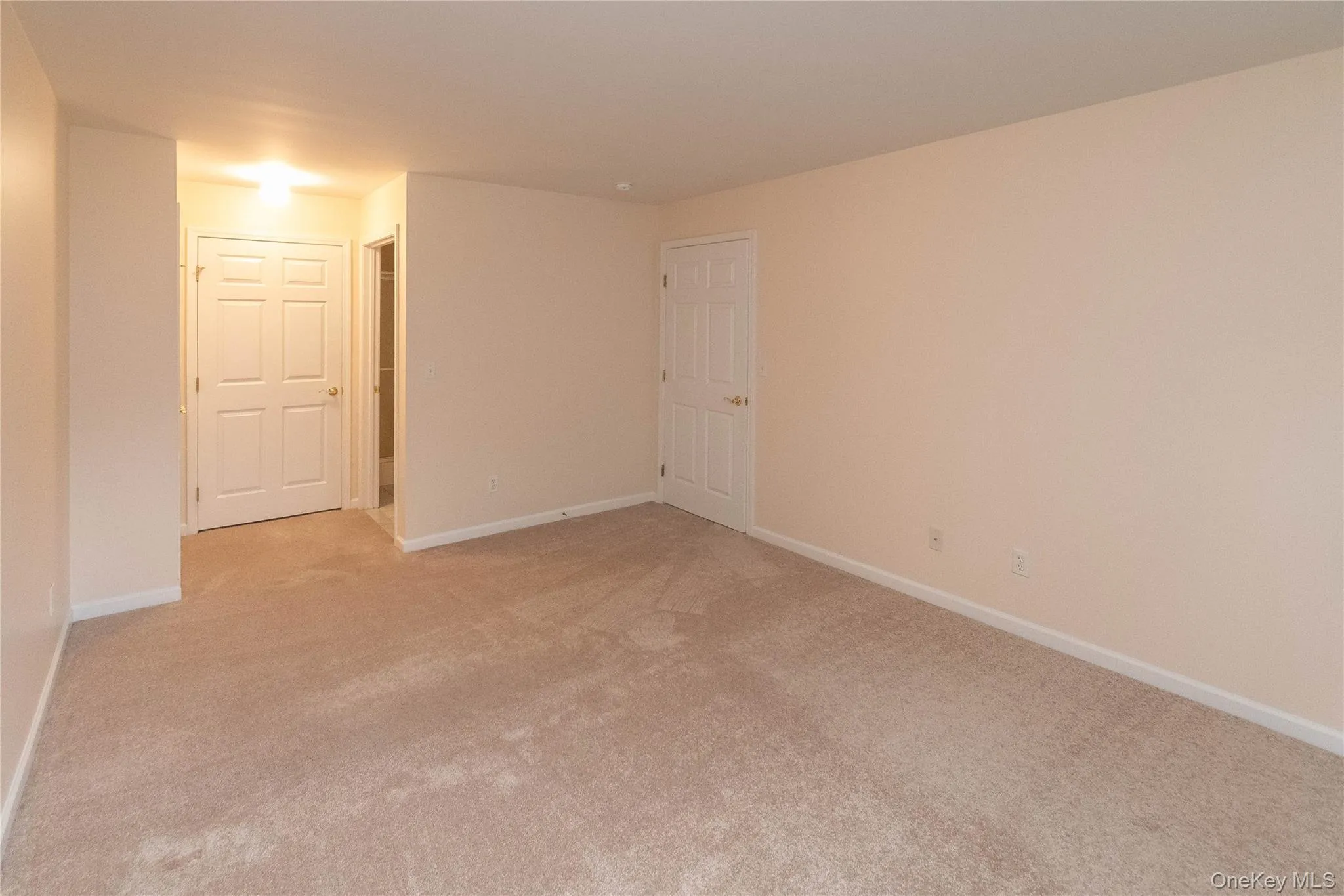 Unfurnished room with baseboards and light colored carpet Unfurnished room with baseboards and light colored carpet