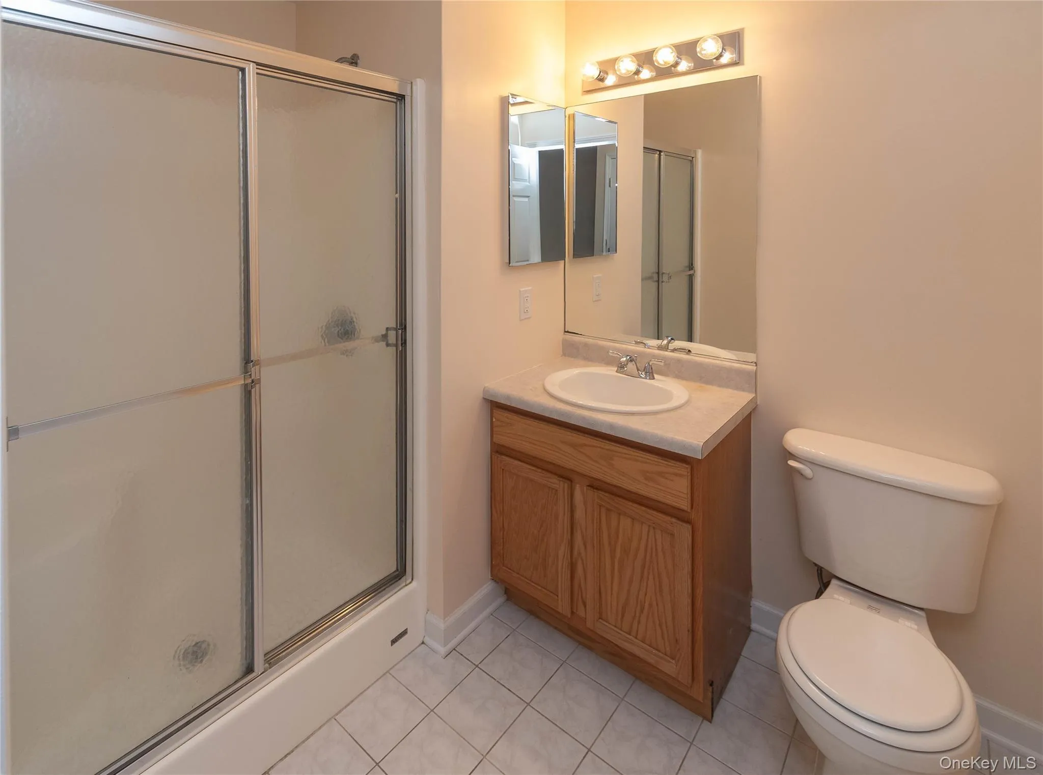 Full bath featuring an enclosed shower, tile patterned flooring, and vanity Full bath featuring an enclosed shower, tile patterned flooring, and vanity