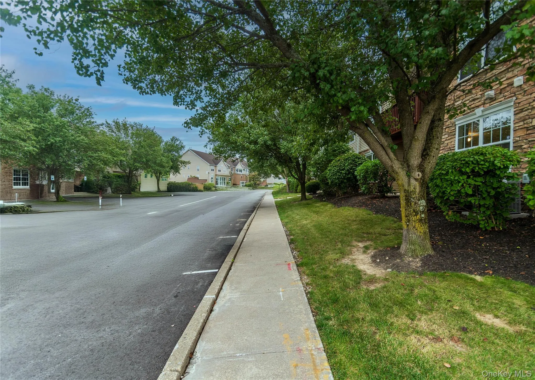 View of asphalt road with curbs and sidewalks View of asphalt road with curbs and sidewalks