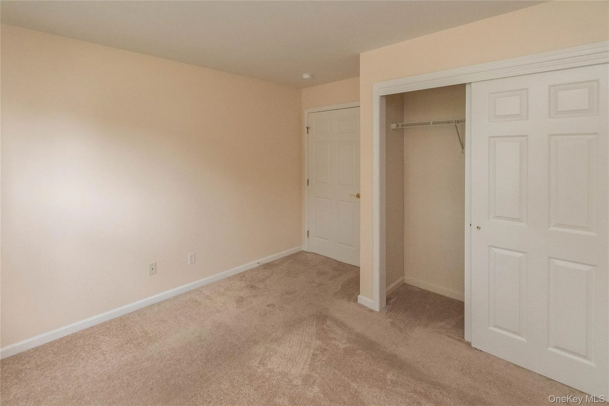 Unfurnished bedroom with light colored carpet and a closet Unfurnished bedroom with light colored carpet and a closet