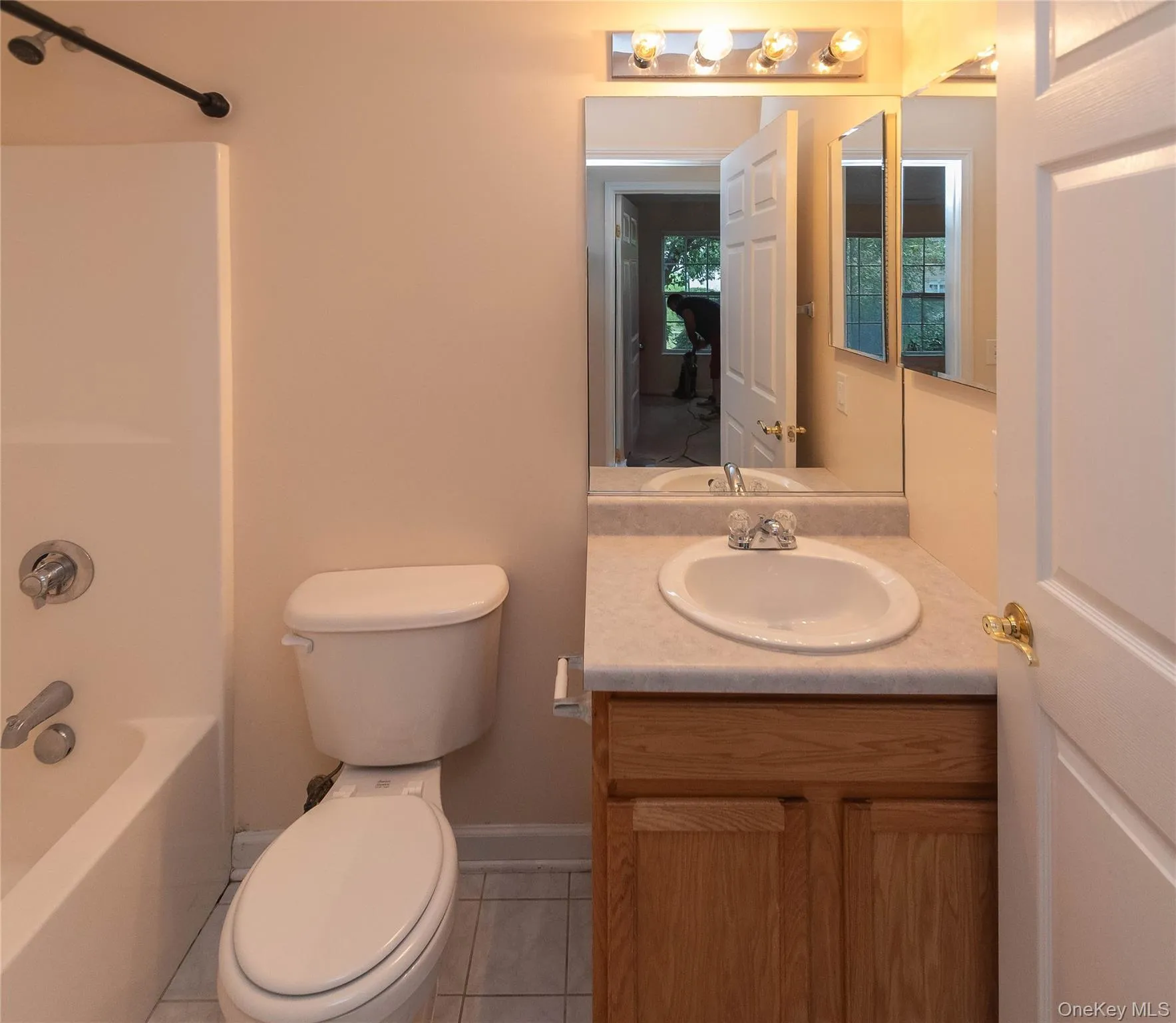 Bathroom featuring tile patterned flooring, vanity, and washtub / shower combination Bathroom featuring tile patterned flooring, vanity, and washtub / shower combination