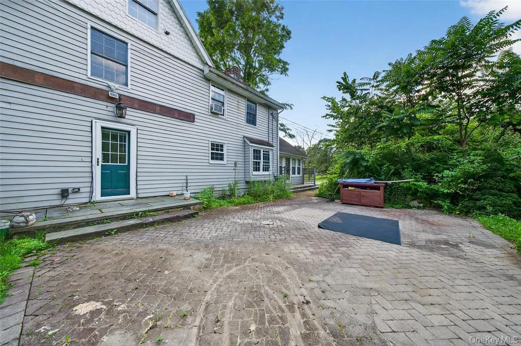 Back of property featuring a patio, a chimney, and a jacuzzi Back of property featuring a patio, a chimney, and a jacuzzi