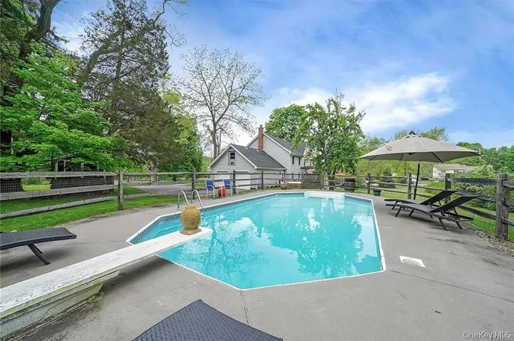 View of pool with a patio area and a diving board View of pool with a patio area and a diving board