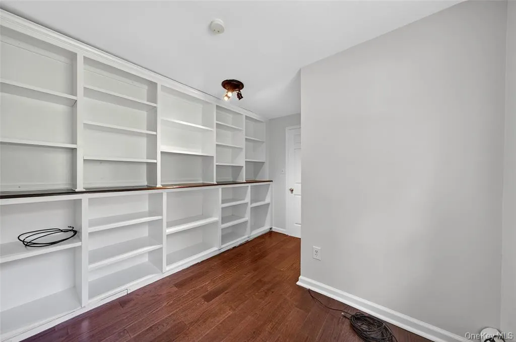 Spacious closet with dark wood-style flooring Spacious closet with dark wood-style flooring
