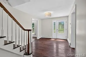Foyer entrance with stairway and wood finished floors Foyer entrance with stairway and wood finished floors