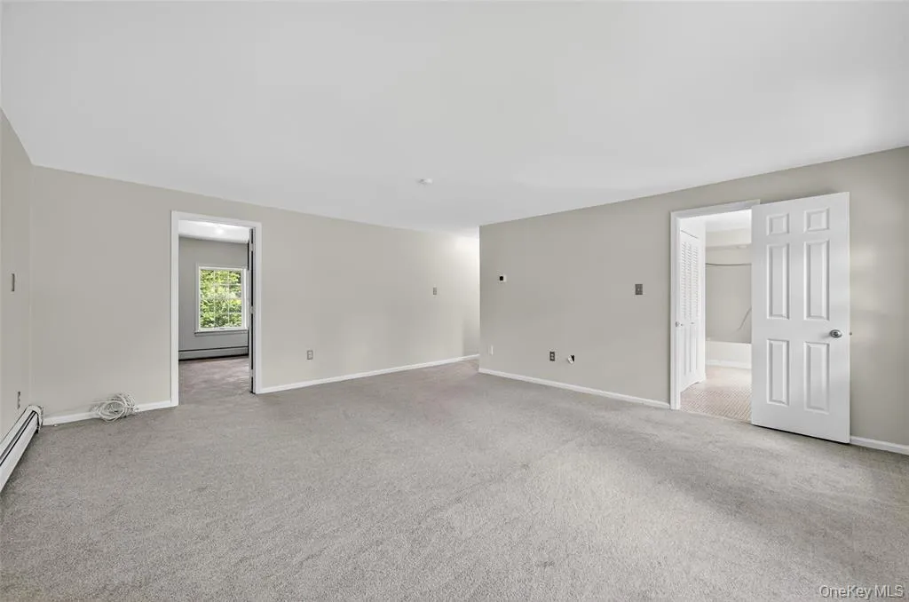 Spare room featuring carpet flooring and baseboard heating Spare room featuring carpet flooring and baseboard heating