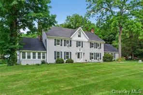 Back of property featuring a lawn and a chimney Back of property featuring a lawn and a chimney