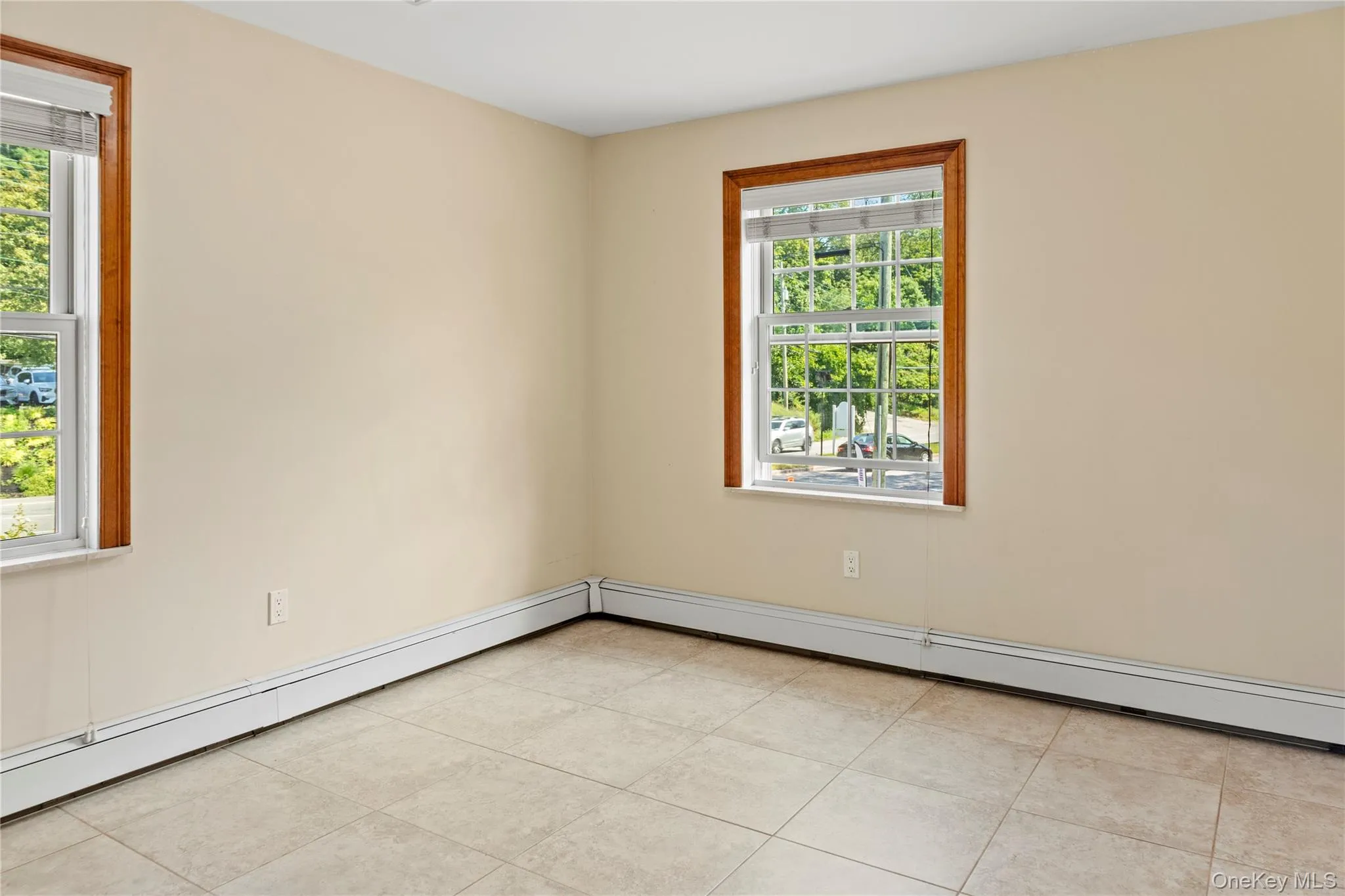 Spare room featuring a baseboard heating unit, healthy amount of natural light, and light tile patterned floors Spare room featuring a baseboard heating unit, healthy amount of natural light, and light tile patterned floors
