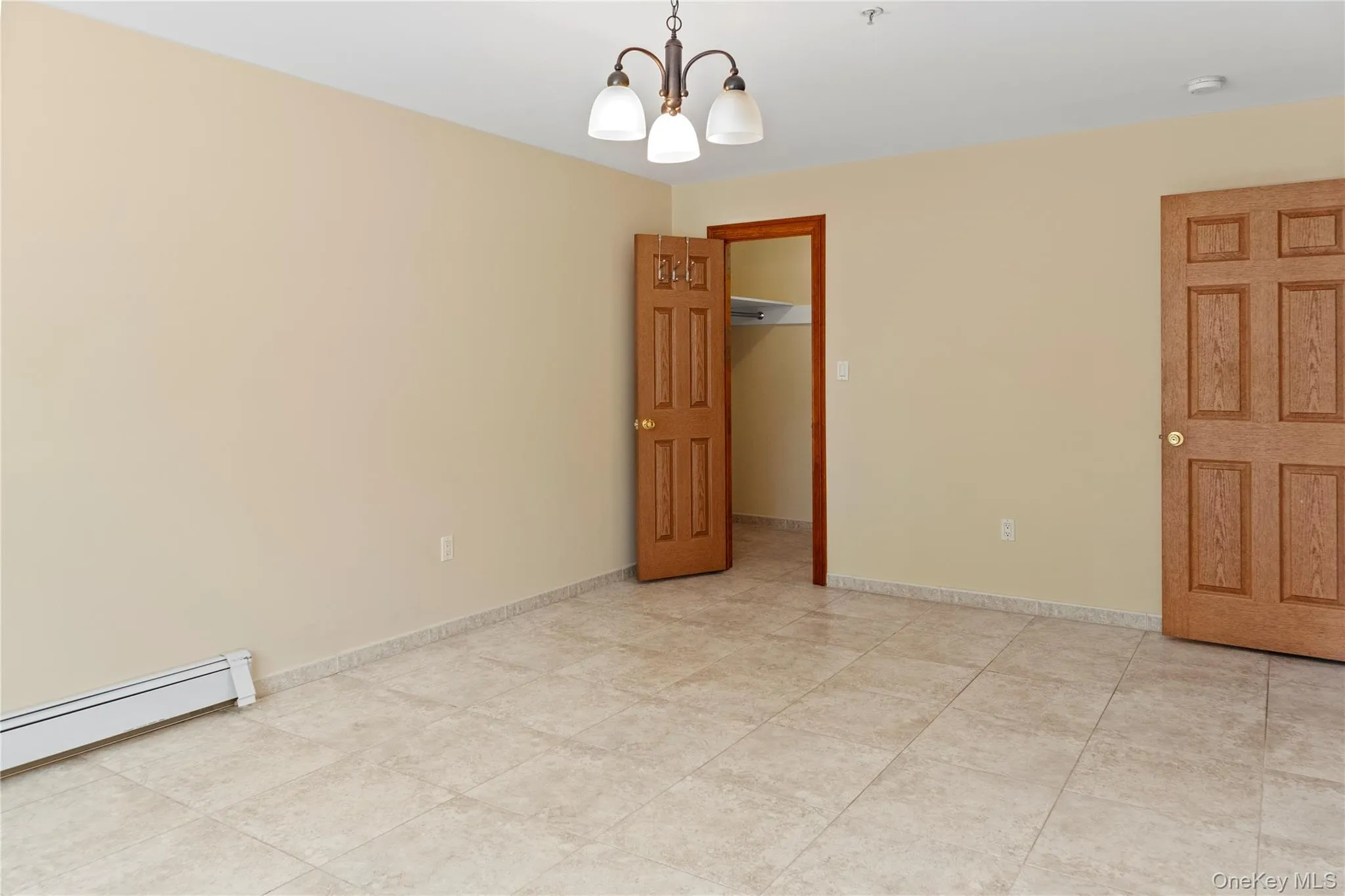 Unfurnished bedroom featuring a chandelier and a spacious closet Unfurnished bedroom featuring a chandelier and a spacious closet