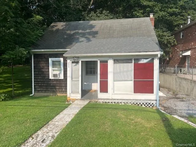 Cape cod house featuring a chimney and a shingled roof Cape cod house featuring a chimney and a shingled roof