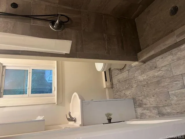 Full bath featuring vanity, a shower stall, wood finish floors, and a baseboard radiator Full bath featuring vanity, a shower stall, wood finish floors, and a baseboard radiator