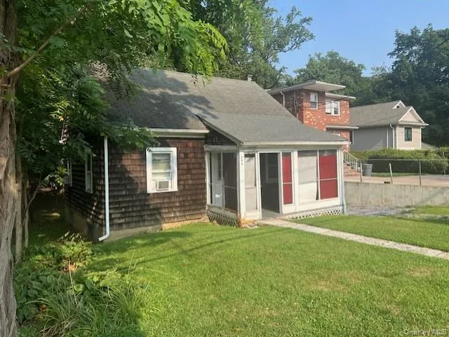 View of front of property featuring a sunroom and roof with shingles View of front of property featuring a sunroom and roof with shingles