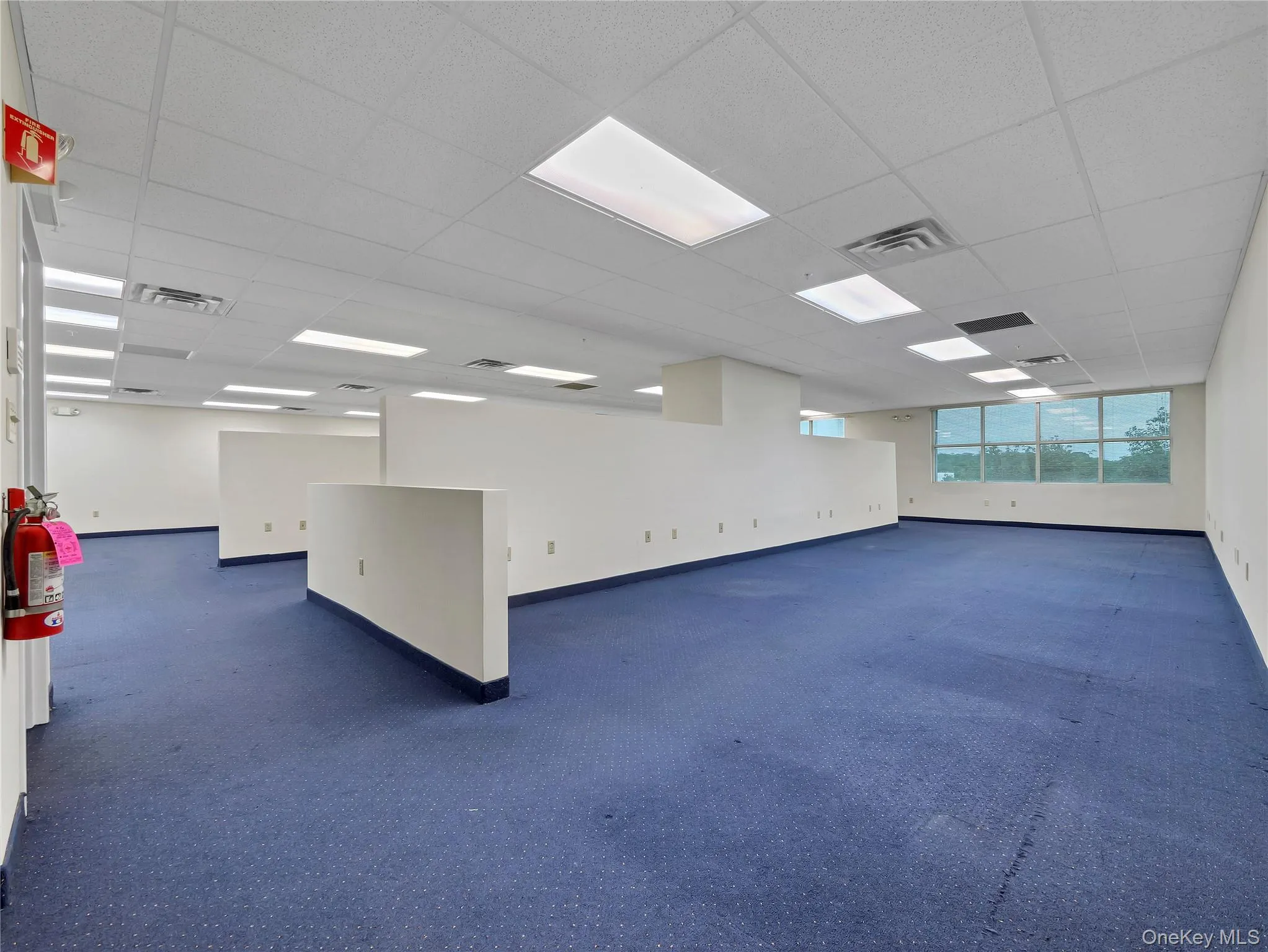 Unfurnished room with a drop ceiling and baseboards Unfurnished room with a drop ceiling and baseboards