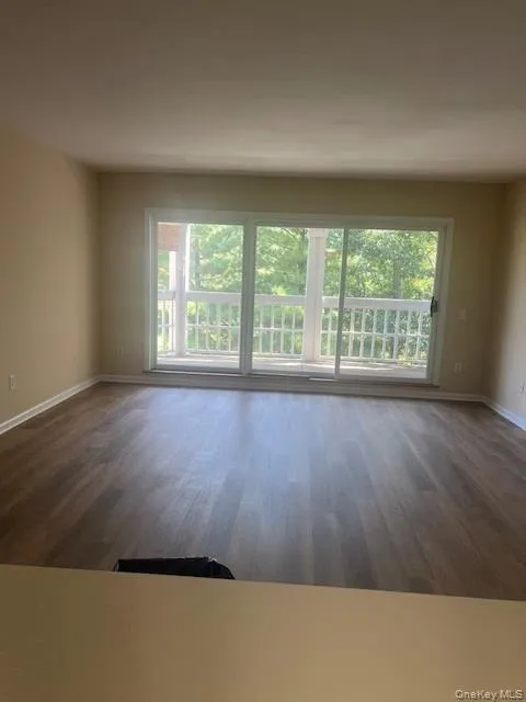 Empty room featuring baseboards and dark wood finished floors Empty room featuring baseboards and dark wood finished floors