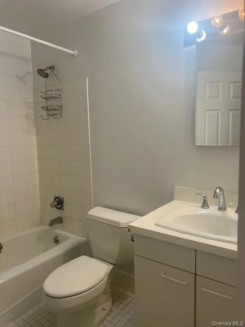 Bathroom featuring shower / bath combination, vanity, and light tile patterned floors Bathroom featuring shower / bath combination, vanity, and light tile patterned floors