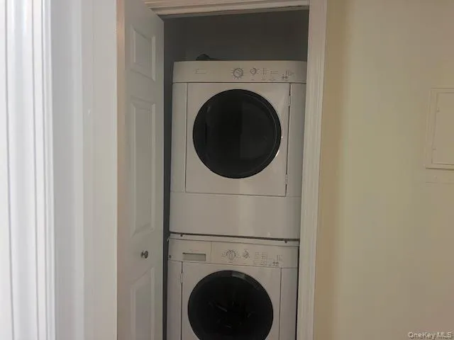 Laundry area featuring stacked washer / drying machine Laundry area featuring stacked washer / drying machine