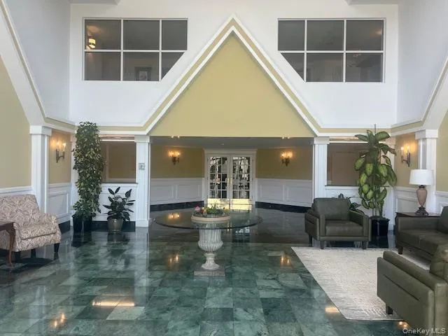 Lobby featuring a decorative wall and a high ceiling Lobby featuring a decorative wall and a high ceiling