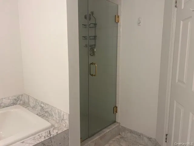 Bathroom featuring a shower stall, a bath, and marble finish flooring Bathroom featuring a shower stall, a bath, and marble finish flooring