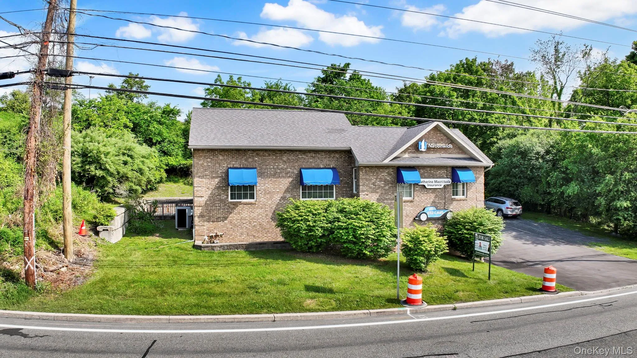 View of front facade featuring driveway, brick siding, a front lawn, and a shingled roof View of front facade featuring driveway, brick siding, a front lawn, and a shingled roof