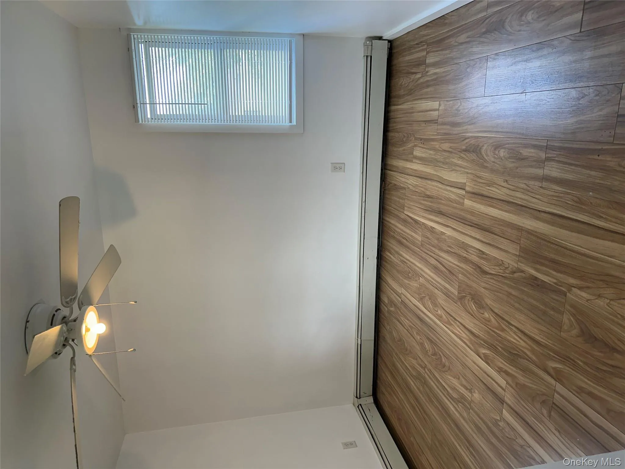 Spare room with wood finished floors, ceiling fan, and a baseboard radiator Spare room with wood finished floors, ceiling fan, and a baseboard radiator