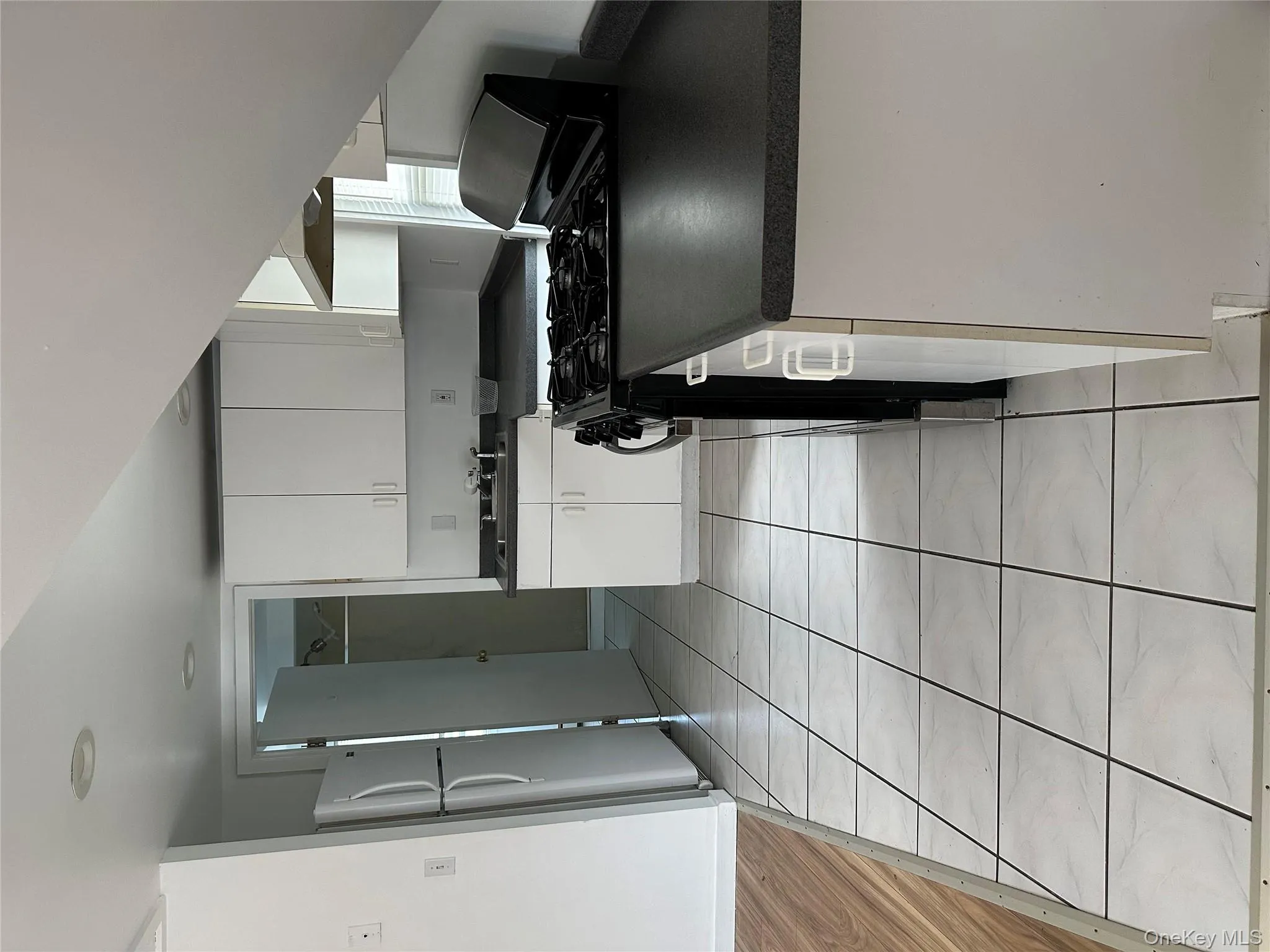 Kitchen featuring range, white cabinetry, light tile patterned flooring, and refrigerator Kitchen featuring range, white cabinetry, light tile patterned flooring, and refrigerator