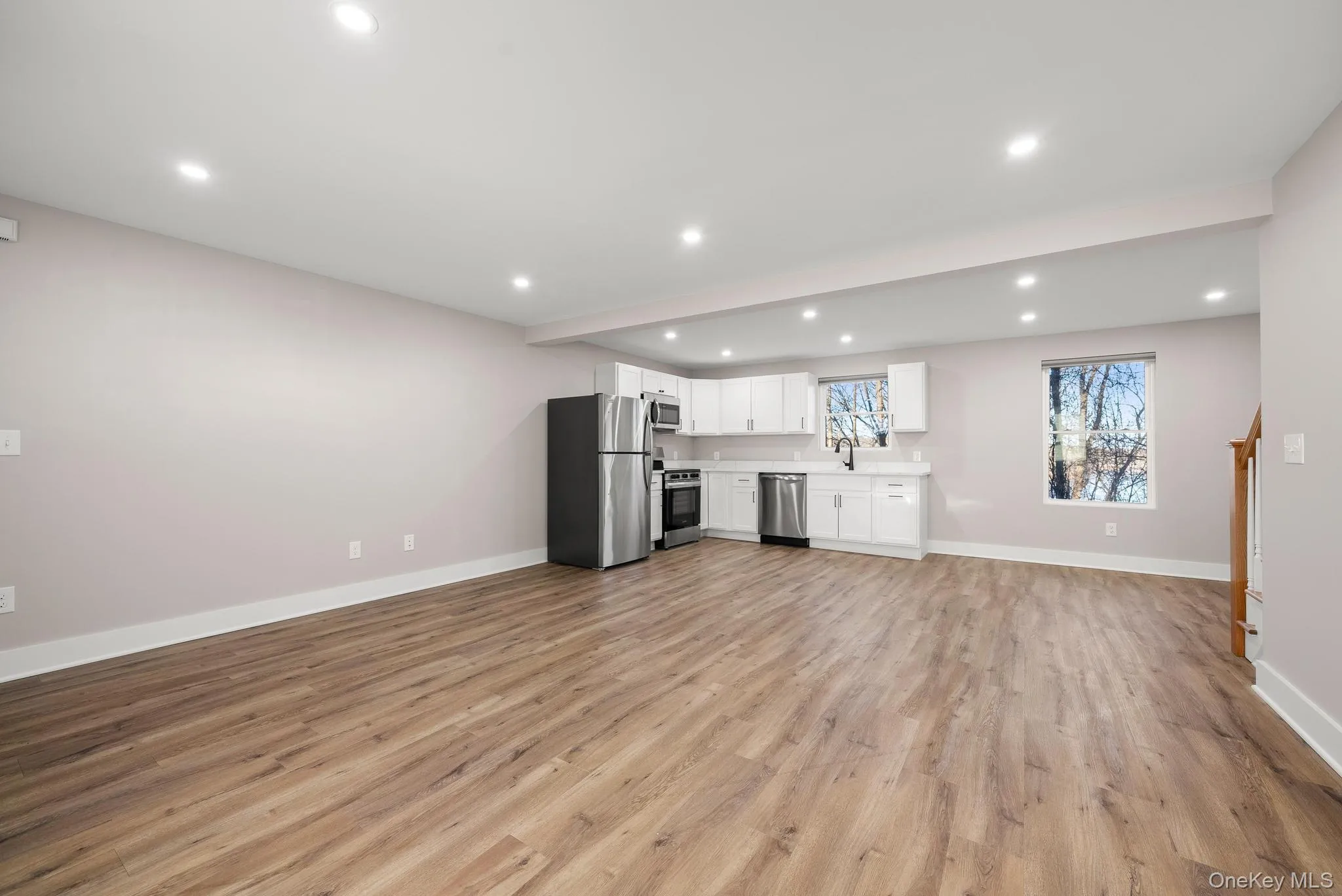 Unfurnished living room with recessed lighting, light wood-style floors, and beamed ceiling Unfurnished living room with recessed lighting, light wood-style floors, and beamed ceiling