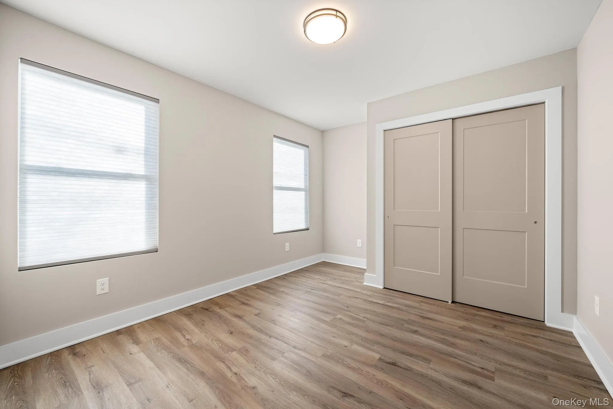 Unfurnished bedroom featuring wood finished floors and a closet Unfurnished bedroom featuring wood finished floors and a closet