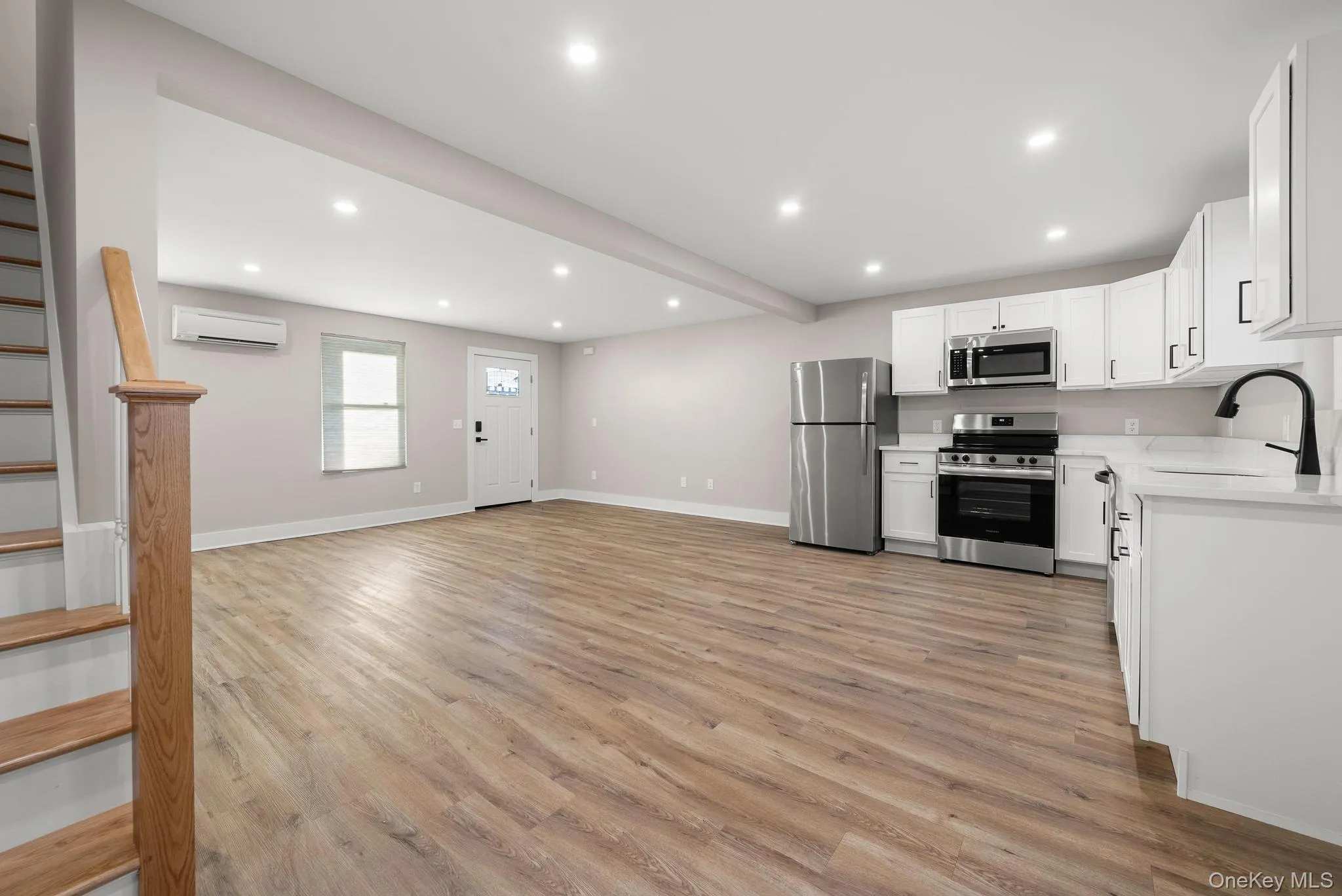 Kitchen with stainless steel appliances, recessed lighting, light wood-style floors, light countertops, and white cabinets Kitchen with stainless steel appliances, recessed lighting, light wood-style floors, light countertops, and white cabinets