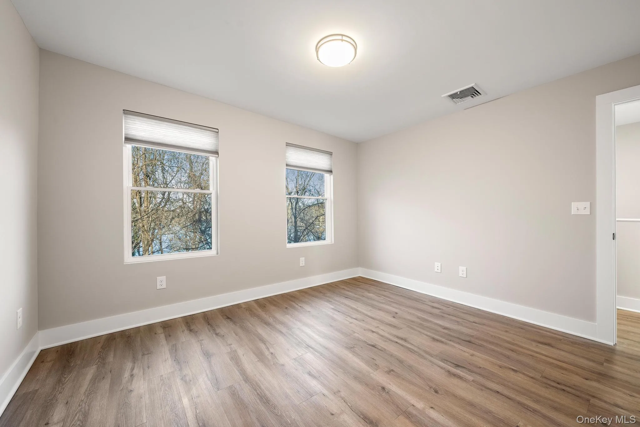 Spare room with wood finished floors and baseboards Spare room with wood finished floors and baseboards
