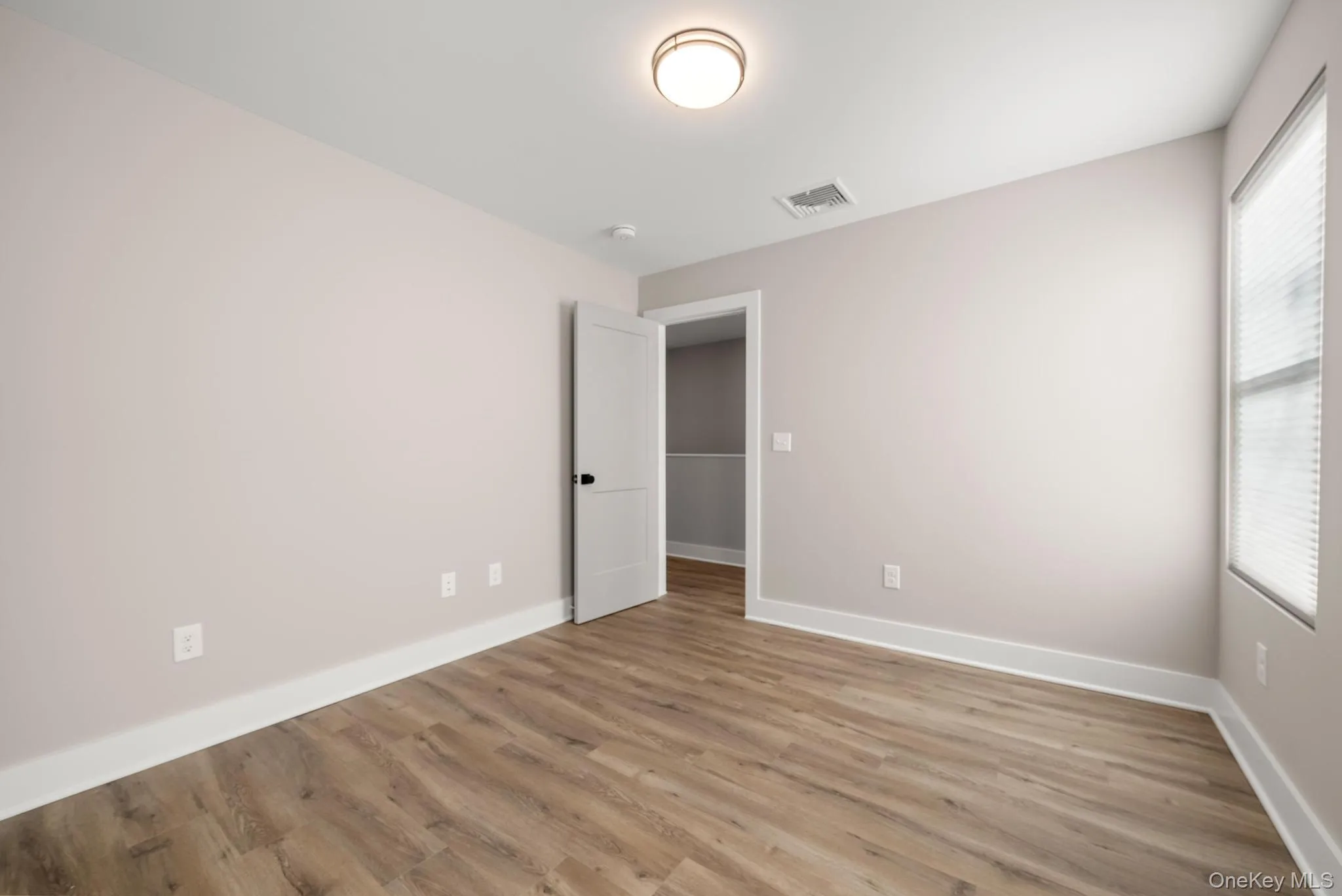 Unfurnished bedroom with light wood-style floors and baseboards Unfurnished bedroom with light wood-style floors and baseboards